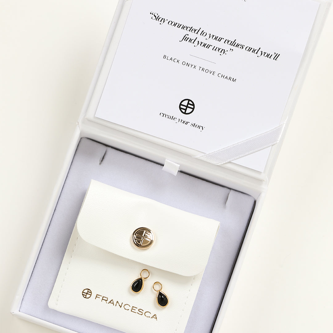 A set of two gold hoop charms with teardrop-shaped Black Onyx stones in white box