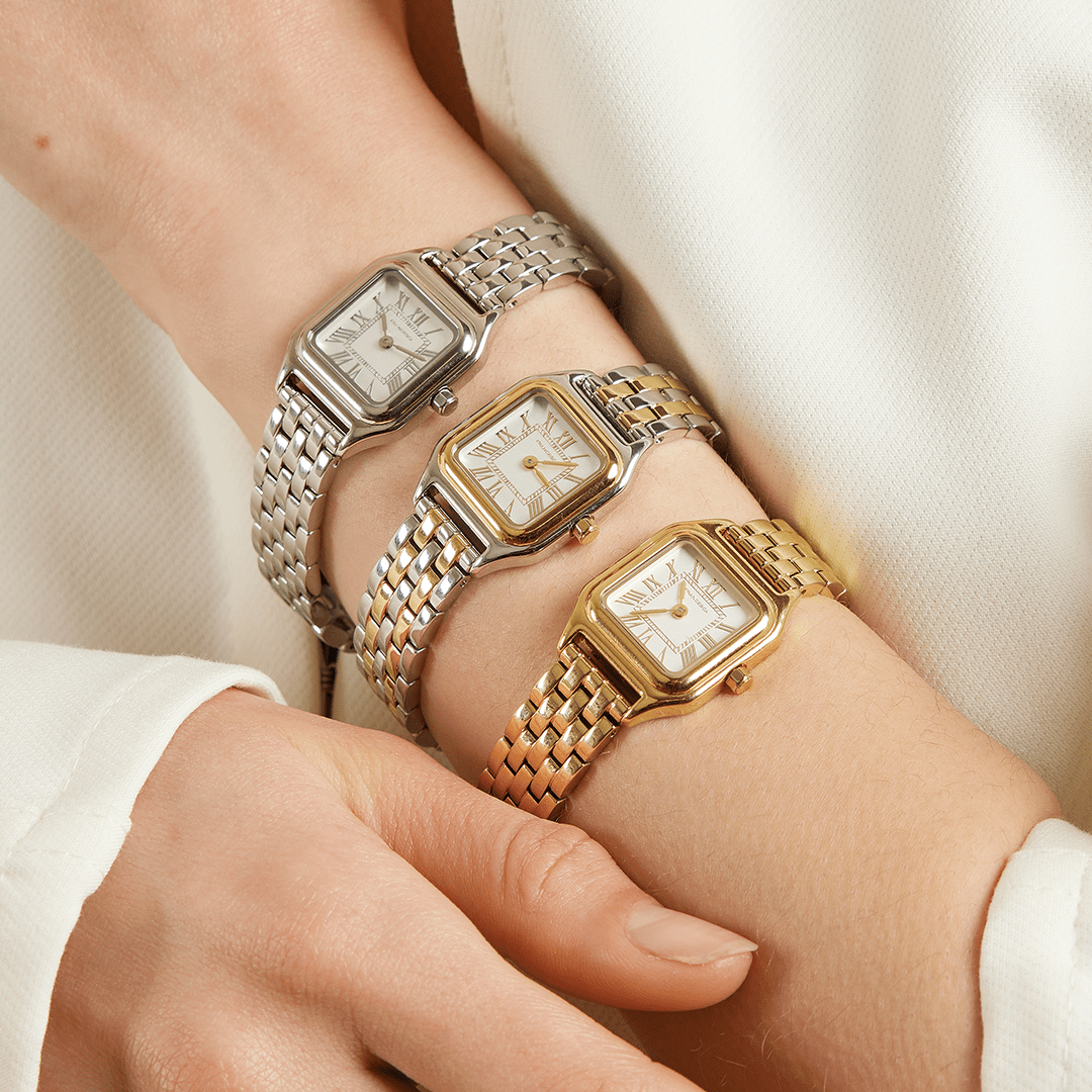A gold-toned, two-toned and silver Louis Watches with a link bracelet and a square face featuring Roman numerals worn on the wrist