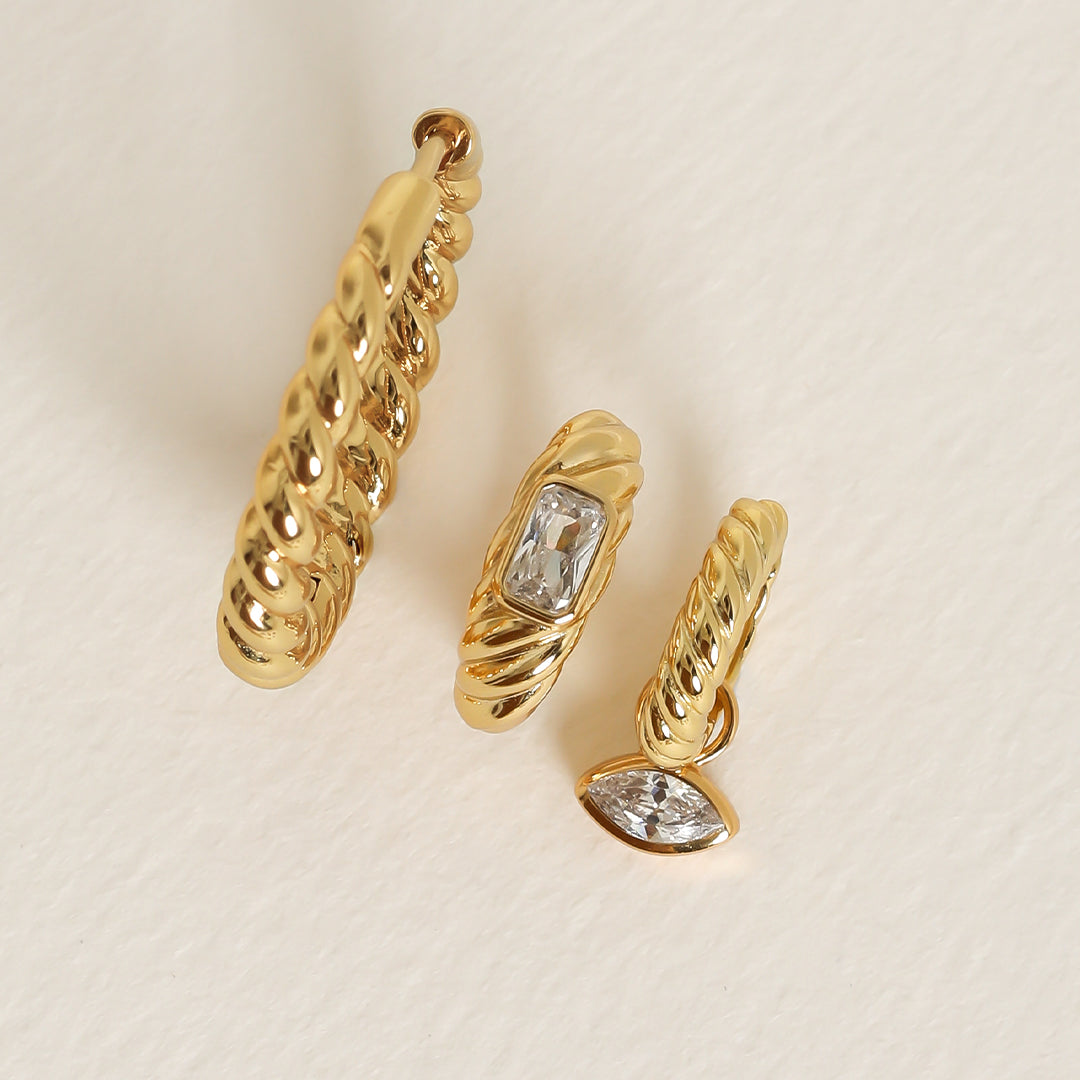 a large and small gold hoop inspired by the Louvre's architecture with Marquise cut white cubic zirconias bezel set hoop charms, ring on white background