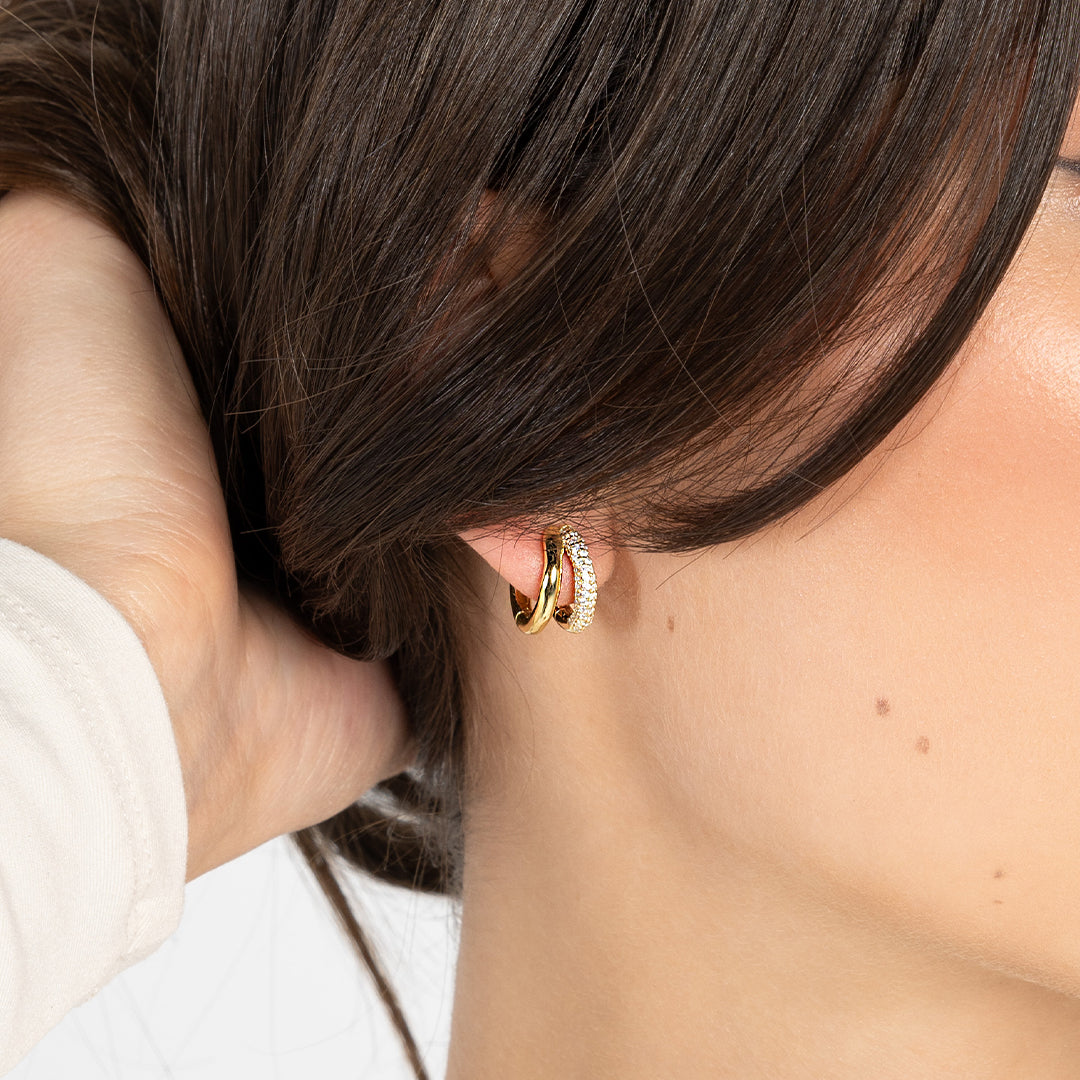 close up shot of gold double huggies with cubic zirconias in ear
