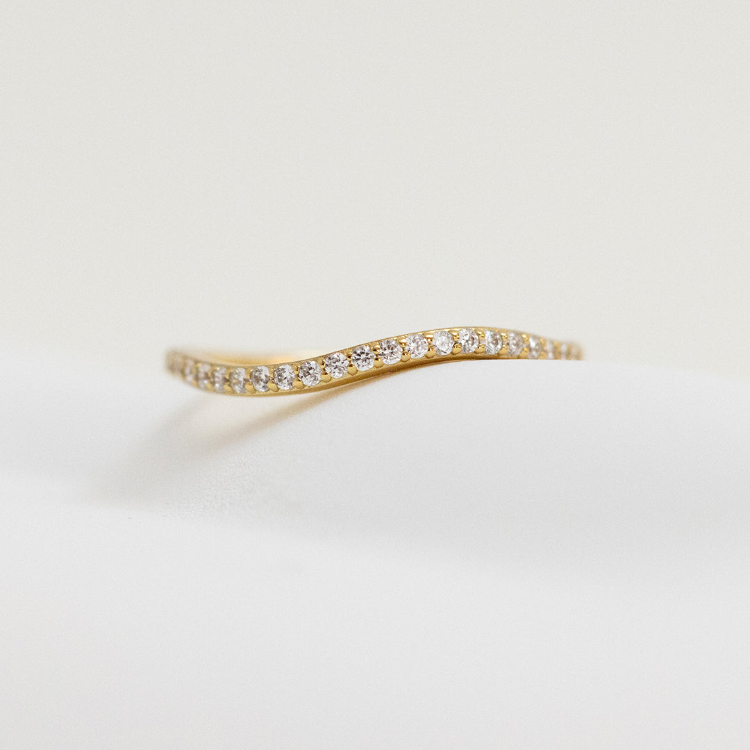 A slim, elegant ring with multiple small cubic zirconias set in a gold coloured band.