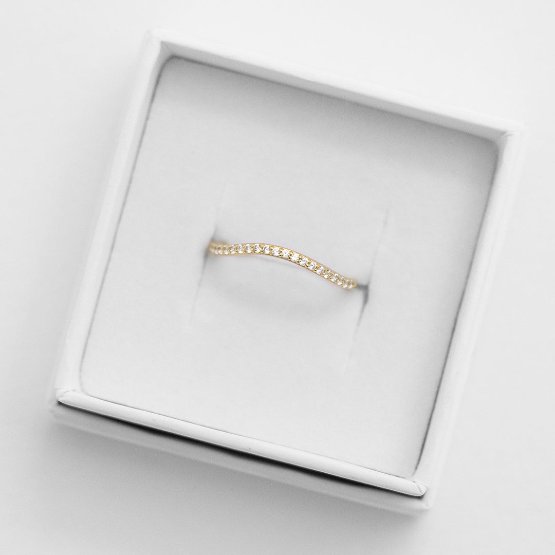 A slim, elegant ring with multiple small cubic zirconias set in a coloured band.