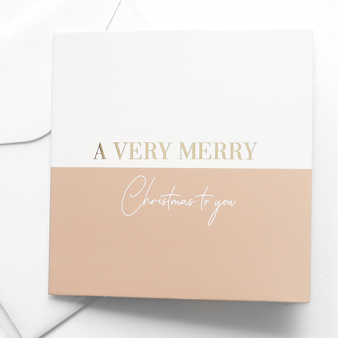 A greeting card with the words 'A VERRY MERRY CHRISTMAS TO YOU' printed in gold and white letters, accompanied by a white envelope.