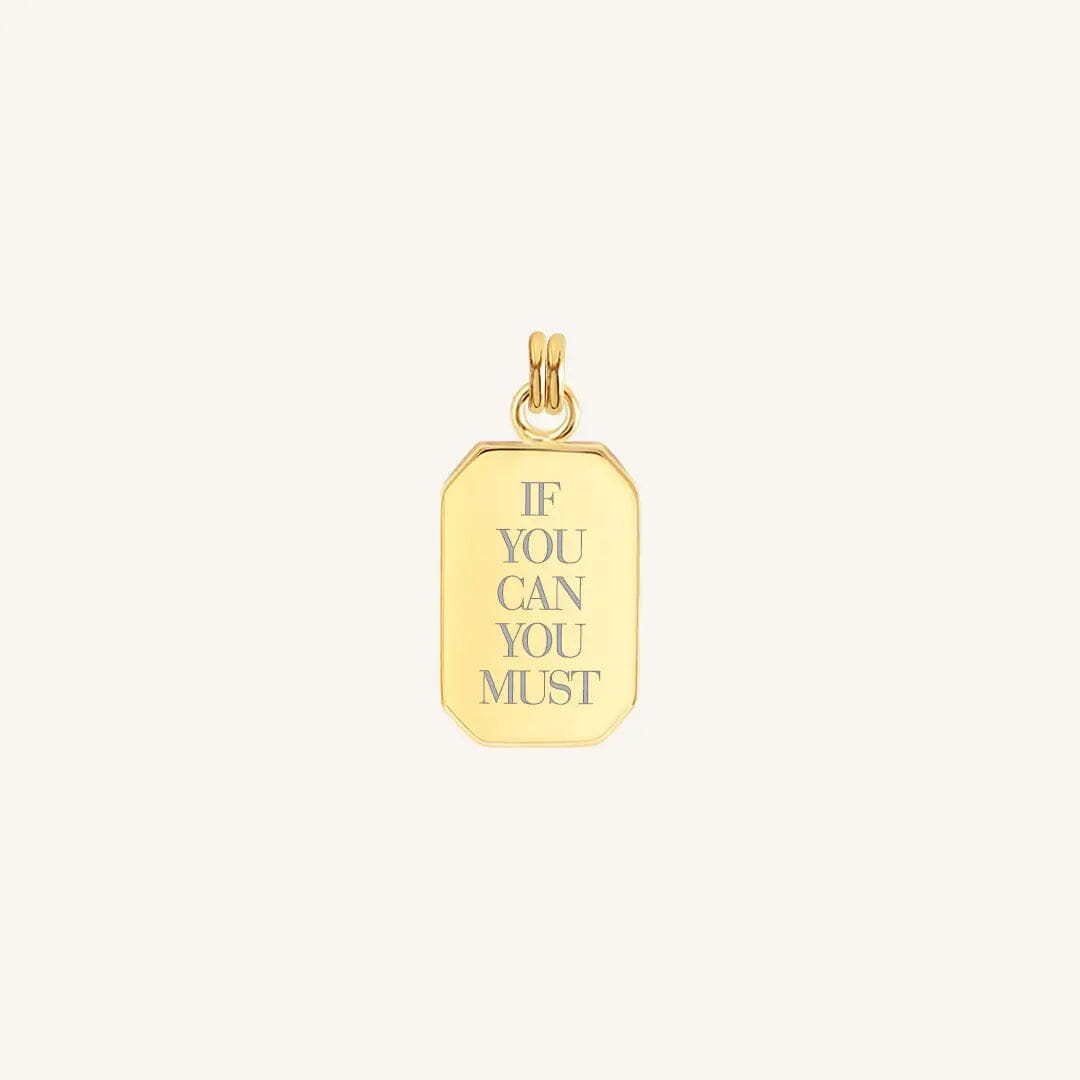 A gold charm with the inscription 'IF YOU CAN YOU MUST' in capital letters.