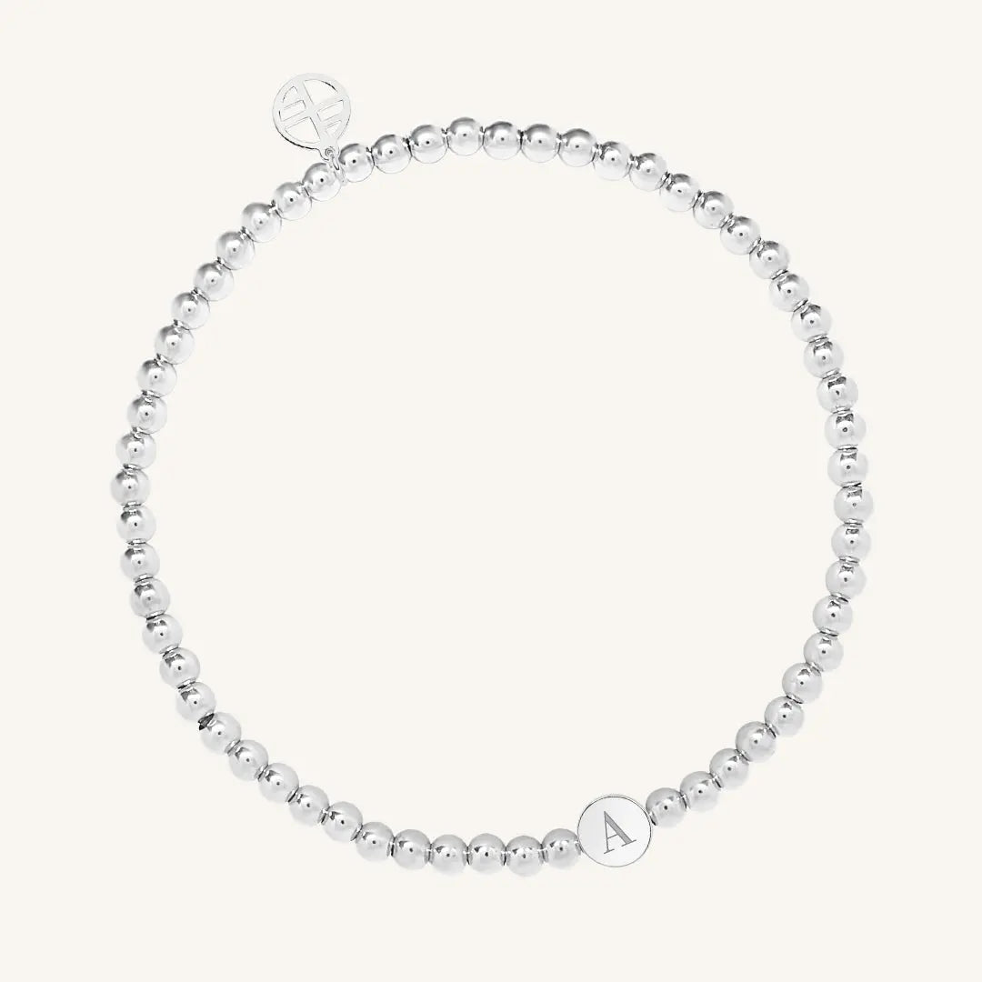 A silver bracelet with a beaded design and an engraveable bead