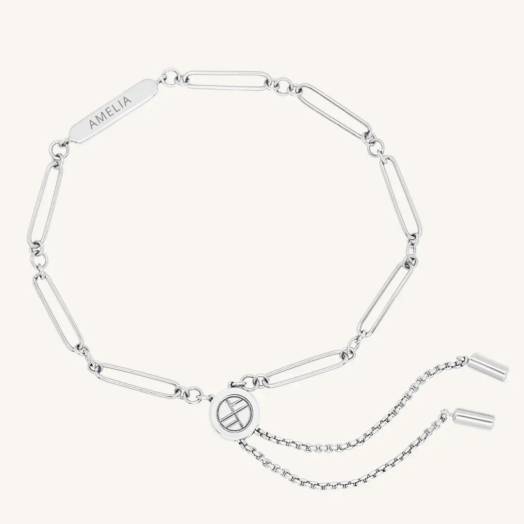 A silver chain bracelet with an adjustable fastening design and an engraveable panel.