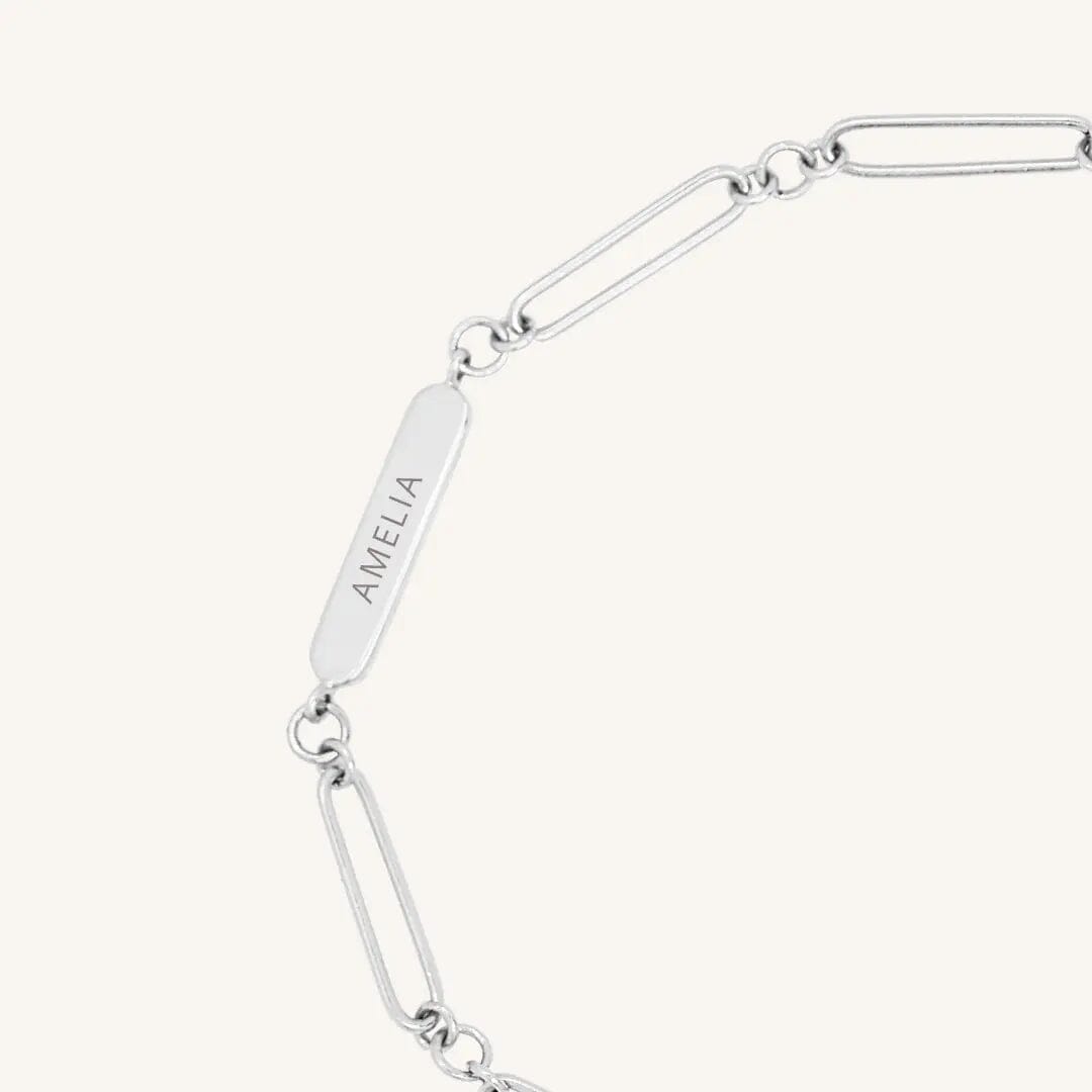 A silver chain bracelet with an adjustable fastening design and an engraveable panel.