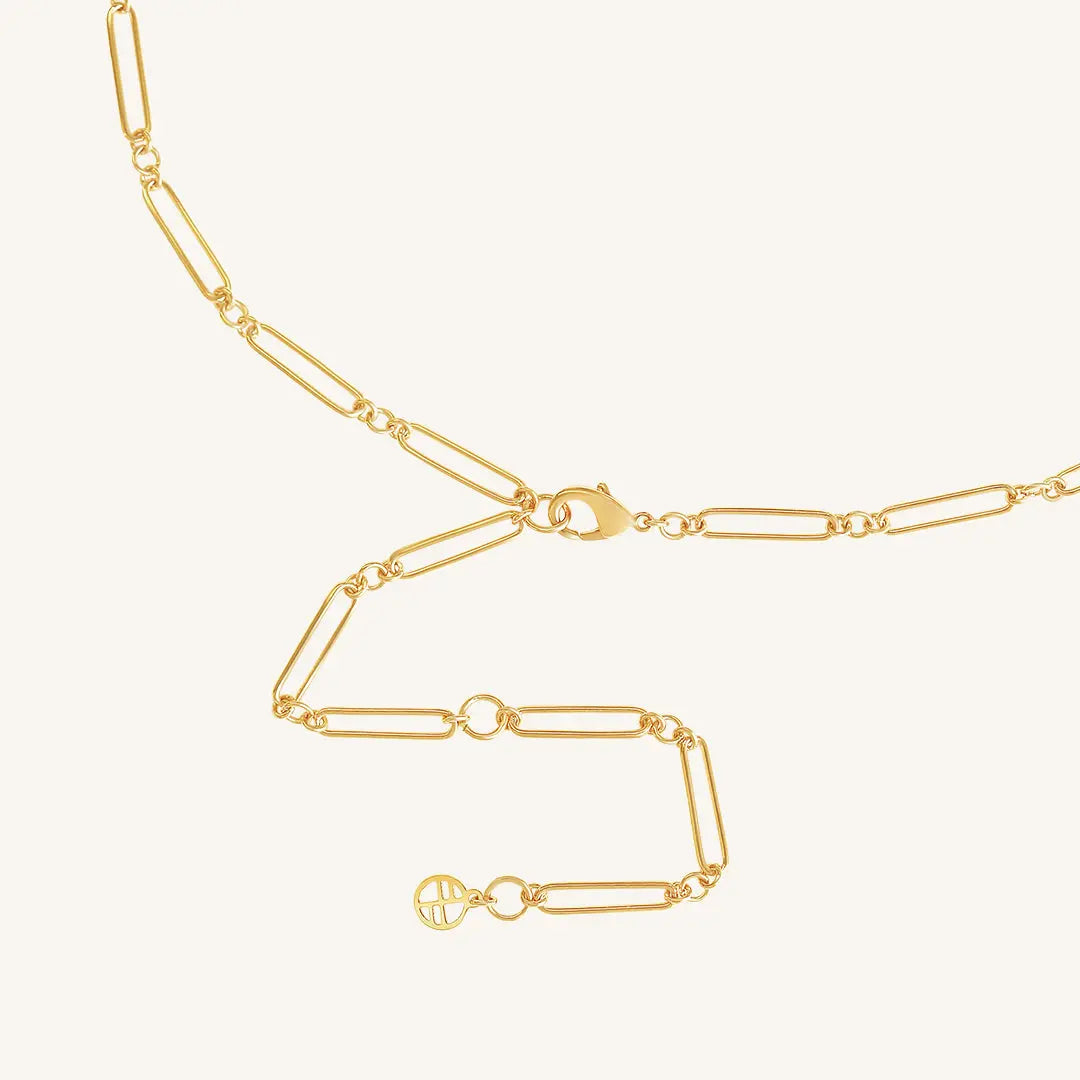 A gold chain necklace with two engraveable panels close up on clasp on a white background