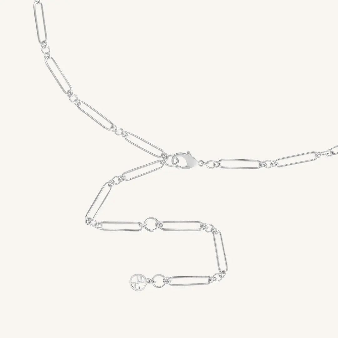 A silver chain necklace with two engraveable panels close up on clasp on a white background