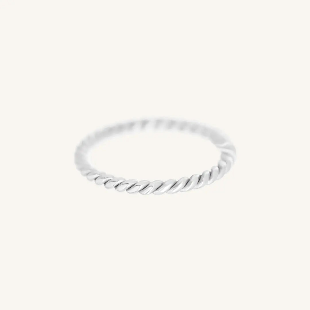 A silver-coloured stacking ring with a twisted design, displayed against a white background.