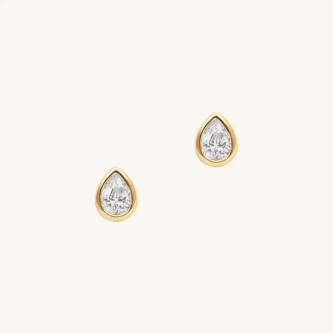 A pair of teardrop-shaped cubic zirconia stud earrings set in gold-tone settings.