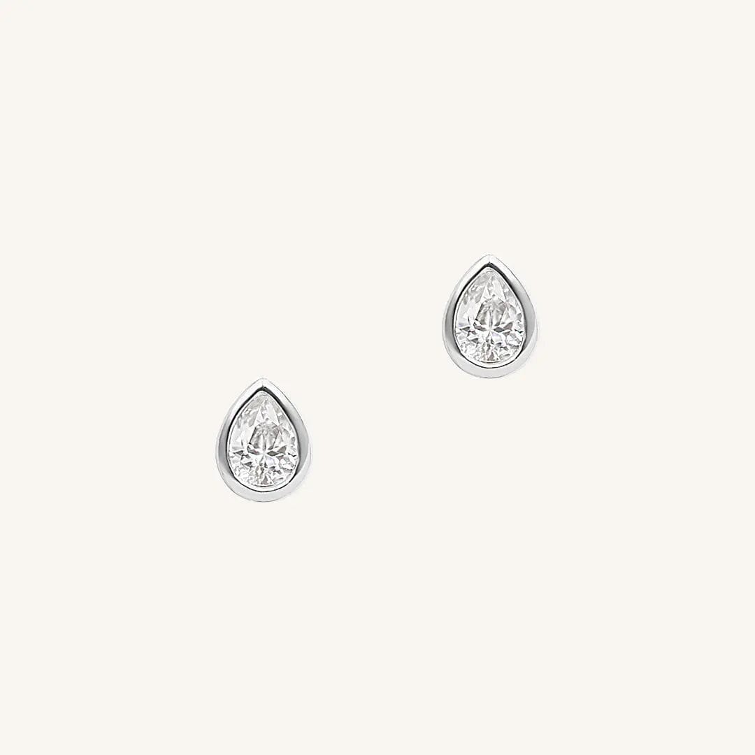A pair of teardrop-shaped cubic zirconia stud earrings set in silver-tone settings.