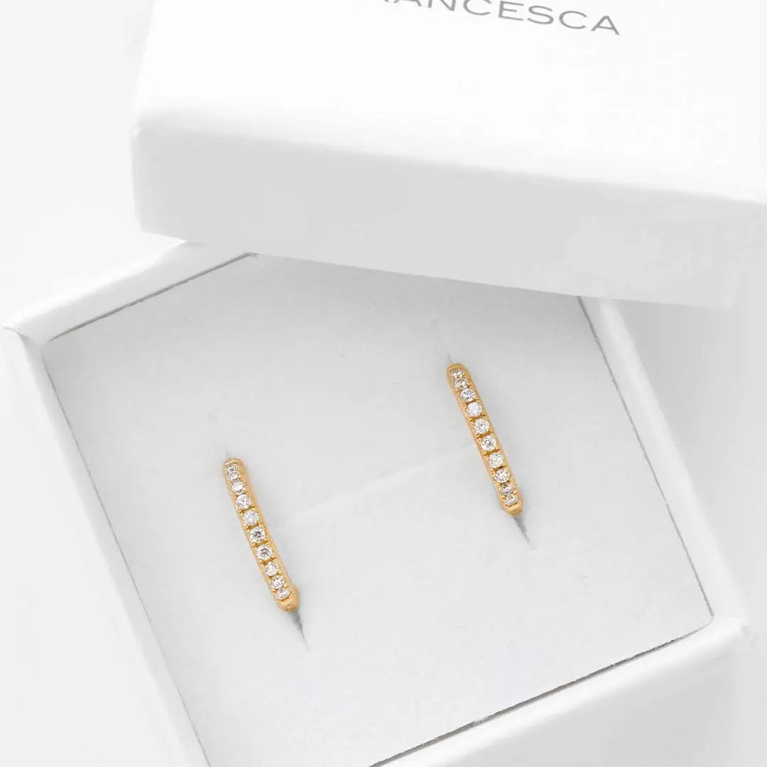 Small gold hoops, with cubic zirconias wrapped around, in white box