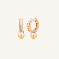 A pair of rose hoop earrings with cubic zirconias with heart charms attached to them, displayed against a white background.