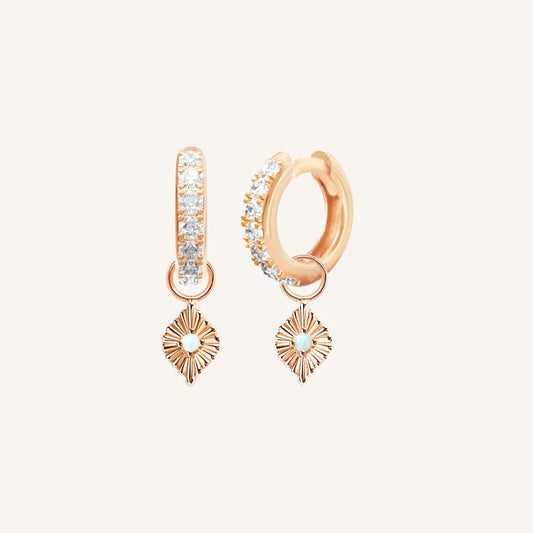 A pair of rose hoop earrings with cubic zirconia and diamond shaped hoop charms featuring a faux opal