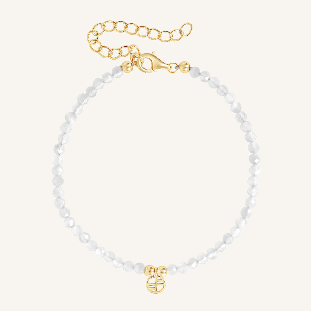 Bracelet with white beads and gold clasp on a white background
