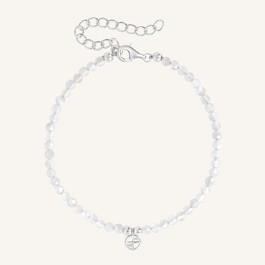 Silver bracelet with a small round charm on a white background