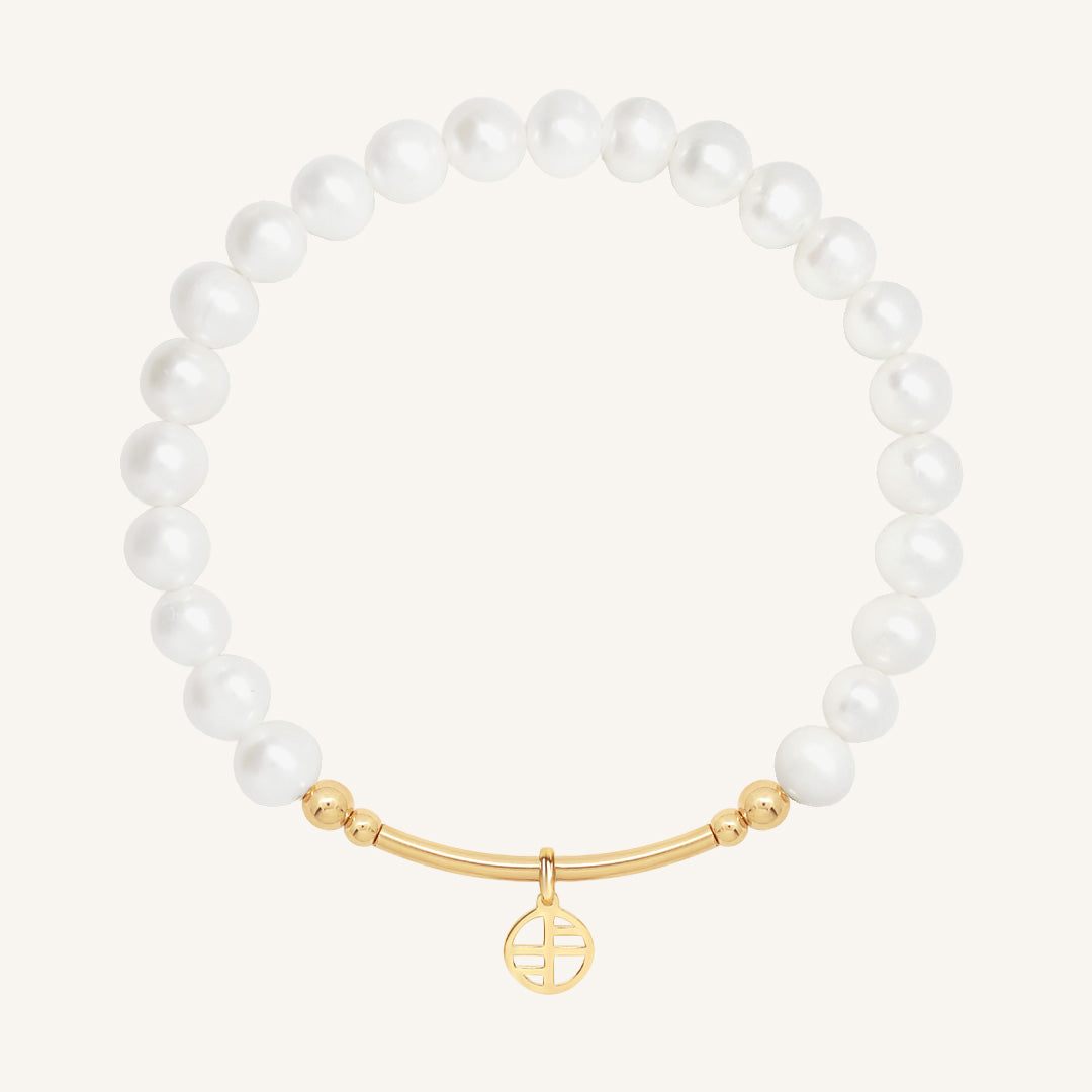 Pearl bracelet with a gold charm on a white background