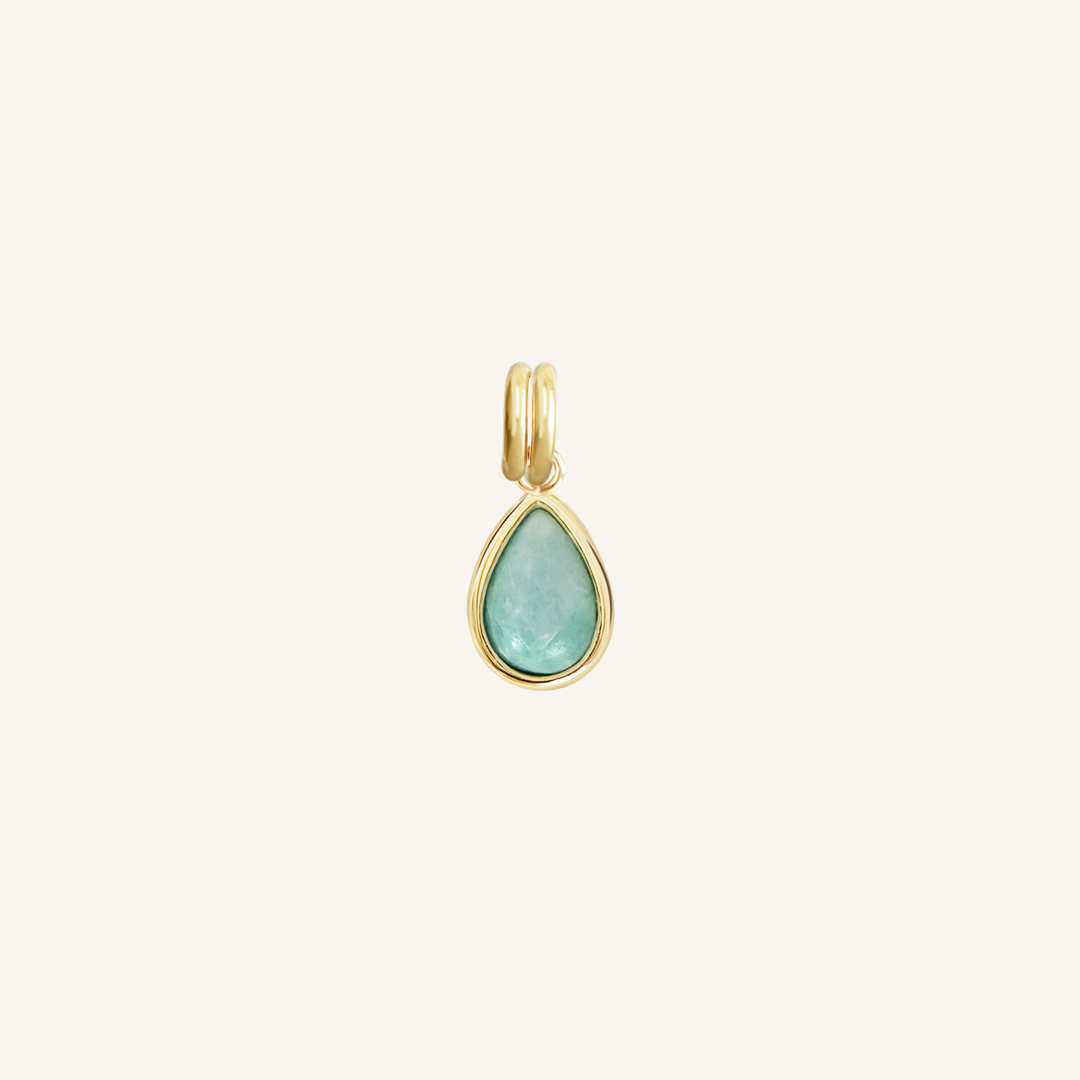 A gold charm with a teardrop-shaped amazonite stone set in a bezel.