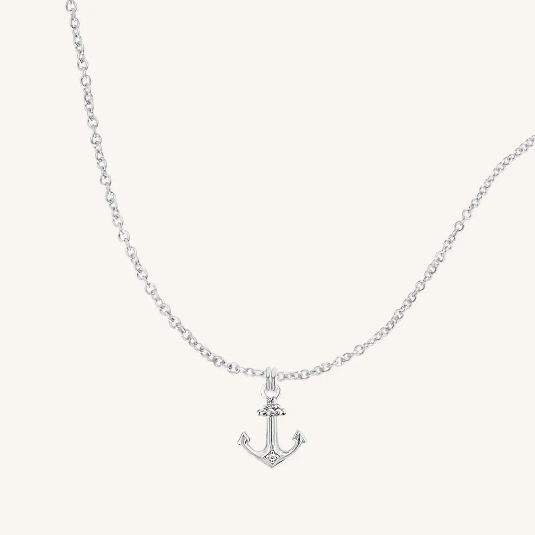 A silver-tone anchor necklace with a small, detailed anchor pendant on a chain.