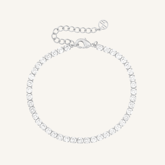 A silver-coloured tennis bracelet with clear cubic zirconias linked together, featuring a extender chain for adjustable length.