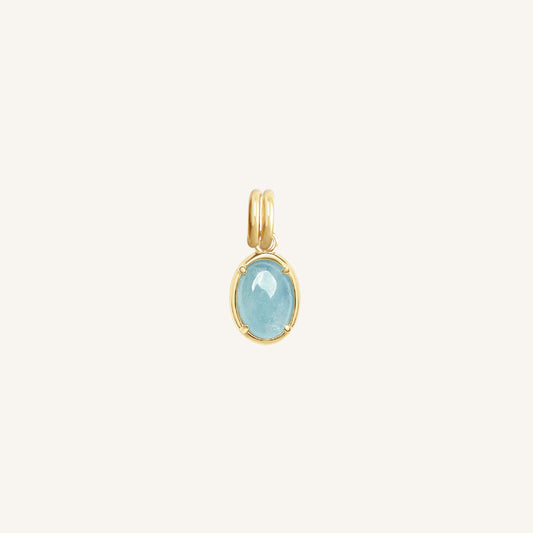 Gold pendant with a blue stone on a white background