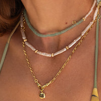 Necklace with light blue beads and gold clasp on a white background