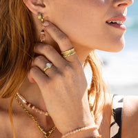 Gold hoop earrings on a light beige background