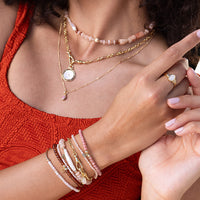 Bracelet with pink beads and gold accents on a white background