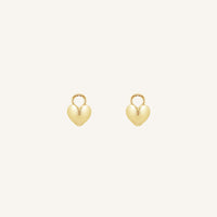 A pair of heart-shaped gold hoop charms against a white background