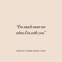 A pair of silver hoop earrings with cubic zirconias with heart charms attached to them, displayed against a white background.