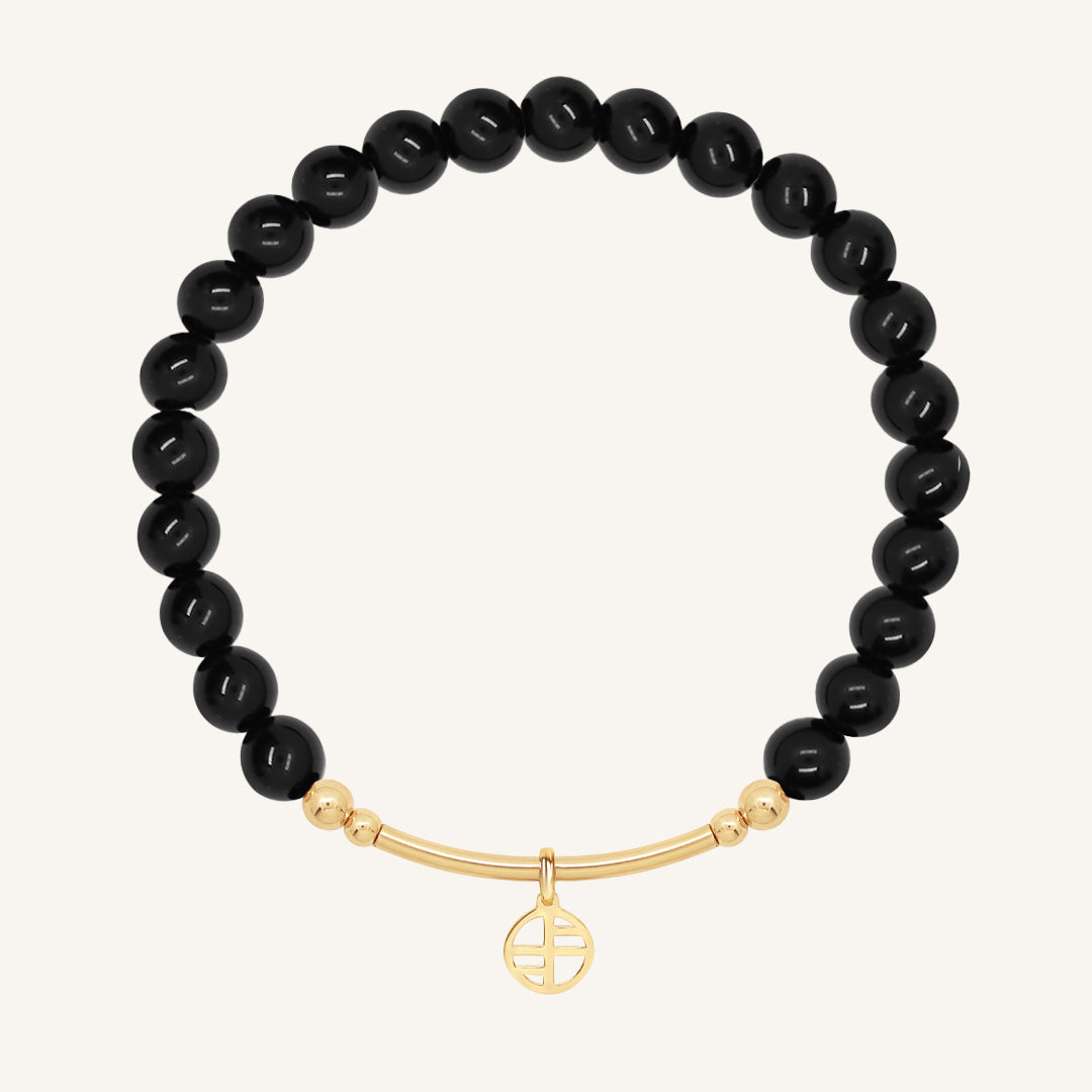 Black beaded bracelet with a gold bar on a white background