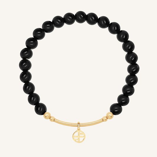 Black beaded bracelet with a gold bar on a white background