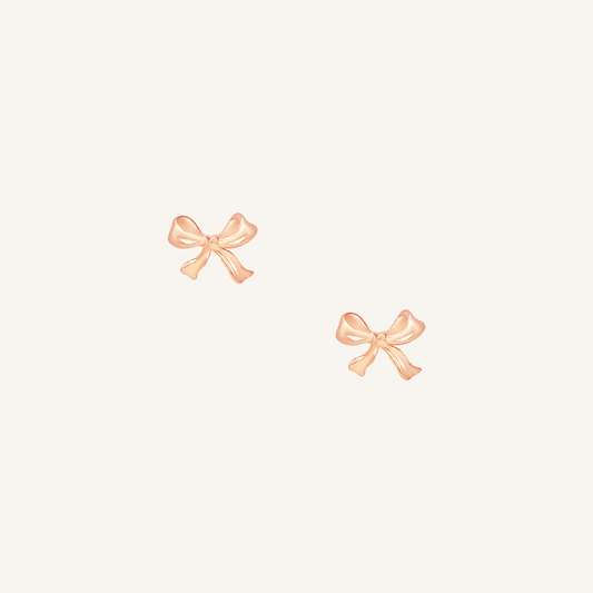 A pair of rose bow stud earrings on a white background