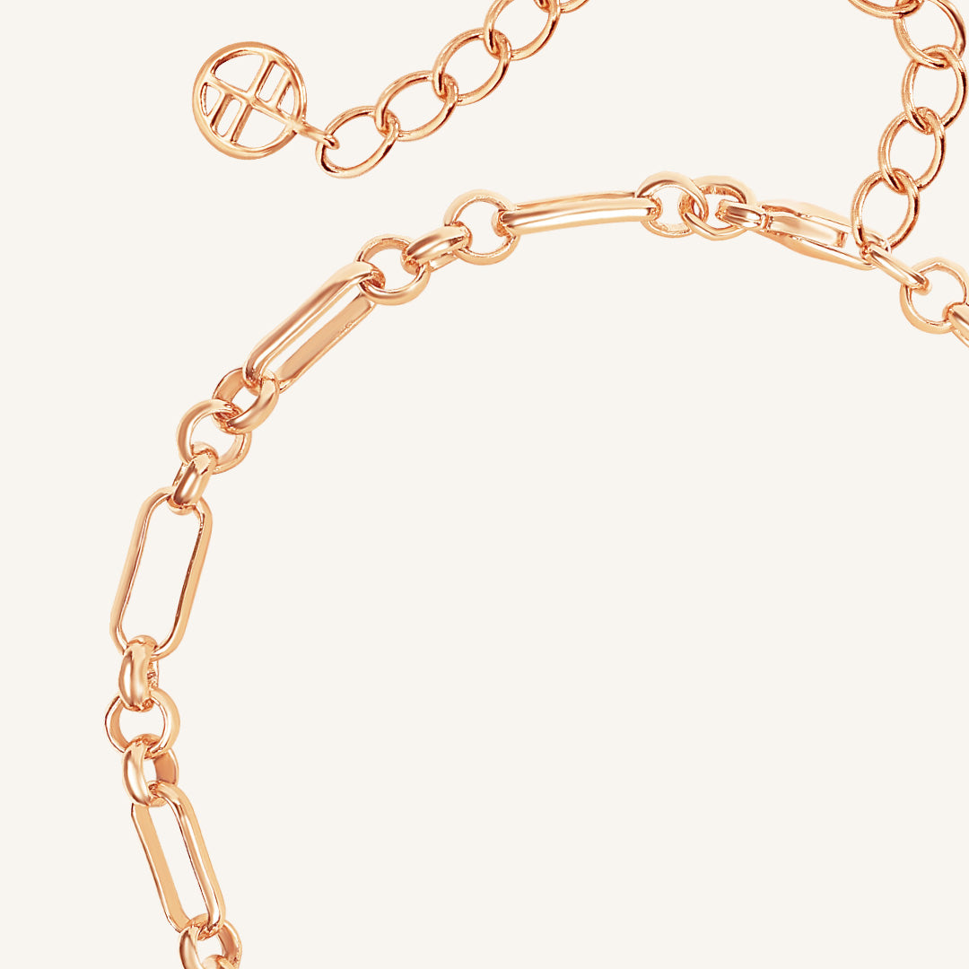 Rose gold chain bracelet on a light pink background