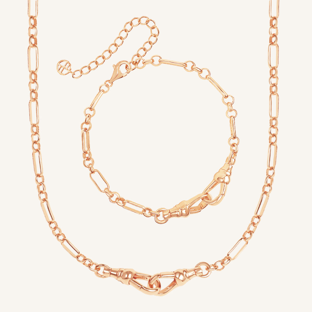 Rose gold chain necklace and bracelet set on a light beige background