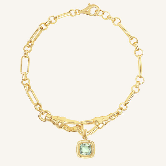 Gold bracelet with a green gemstone charm on a white background