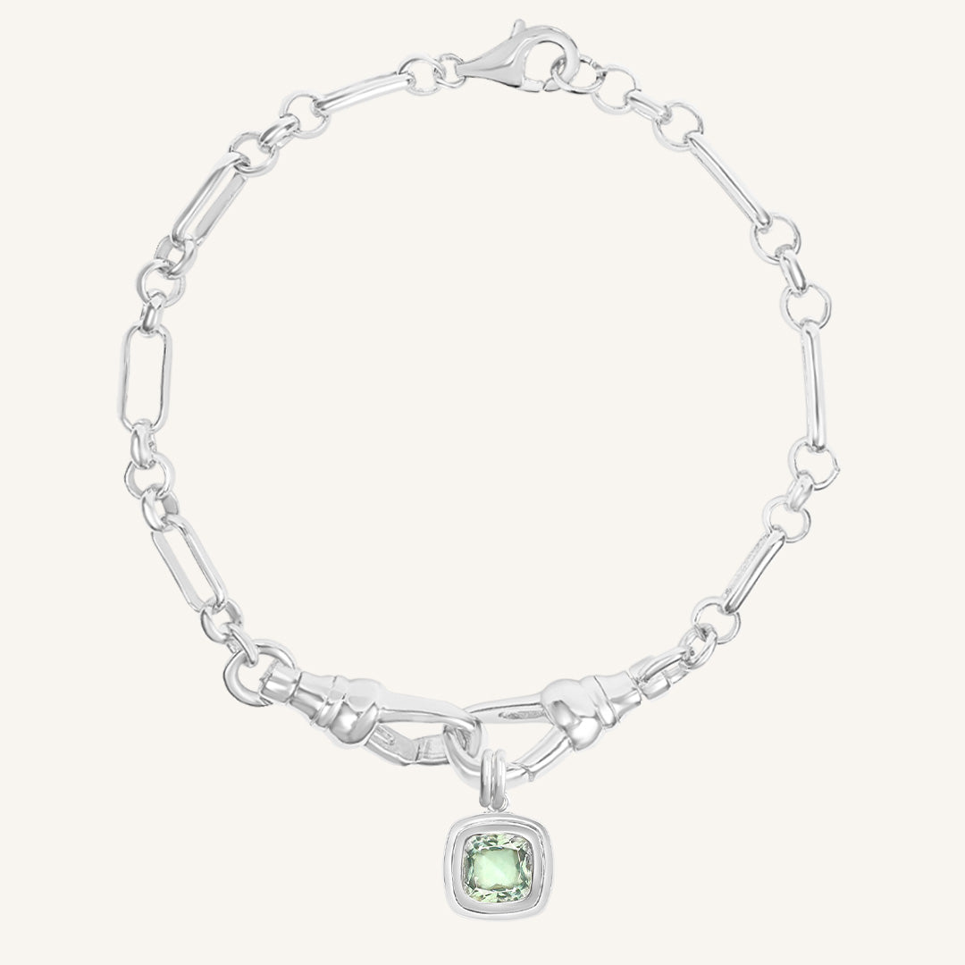 Silver bracelet with a green gemstone charm on a white background