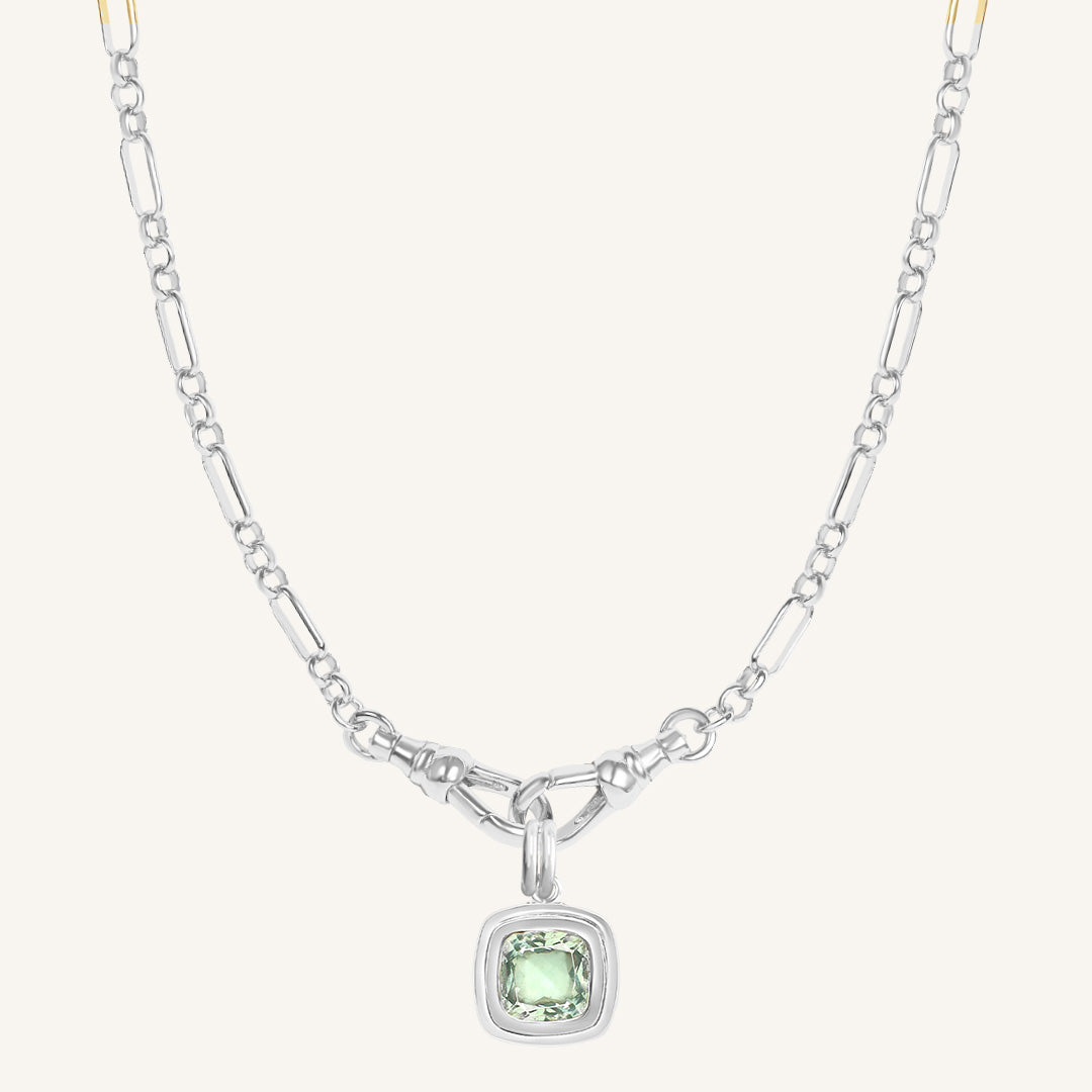 Silver necklace with a green gemstone pendant on a white background