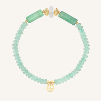 Bracelet with green beads and gold accents on a white background