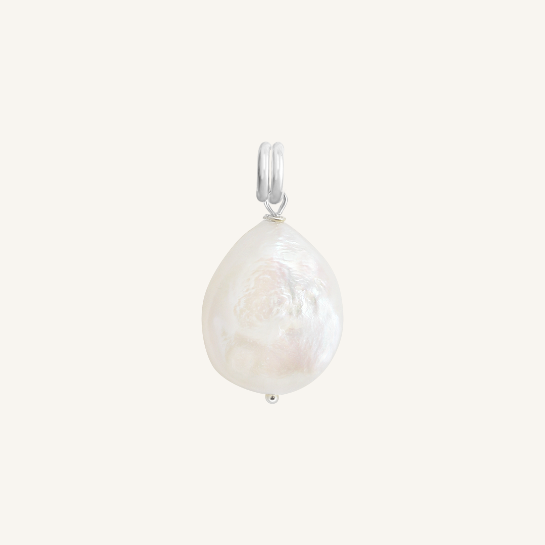 A medium sized pearl charm with silver findings, on white background 
