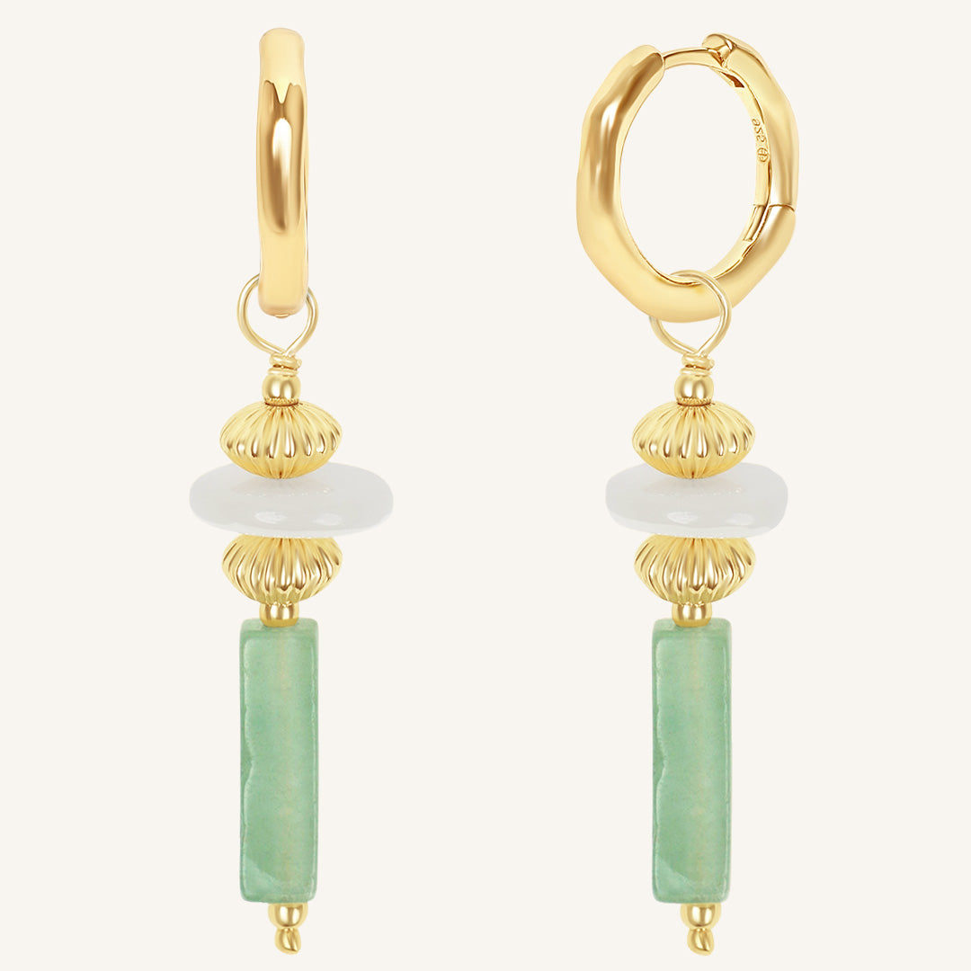 Gold hoop earrings with green and white bead drops on a white background