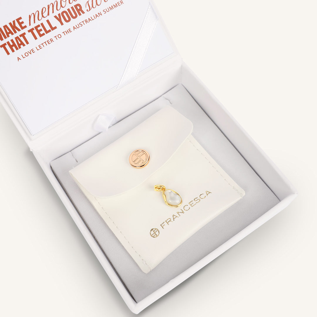 Gold charm in a Francesca branded box with a white background