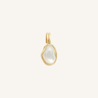 Gold pendant with a white stone on a light beige background