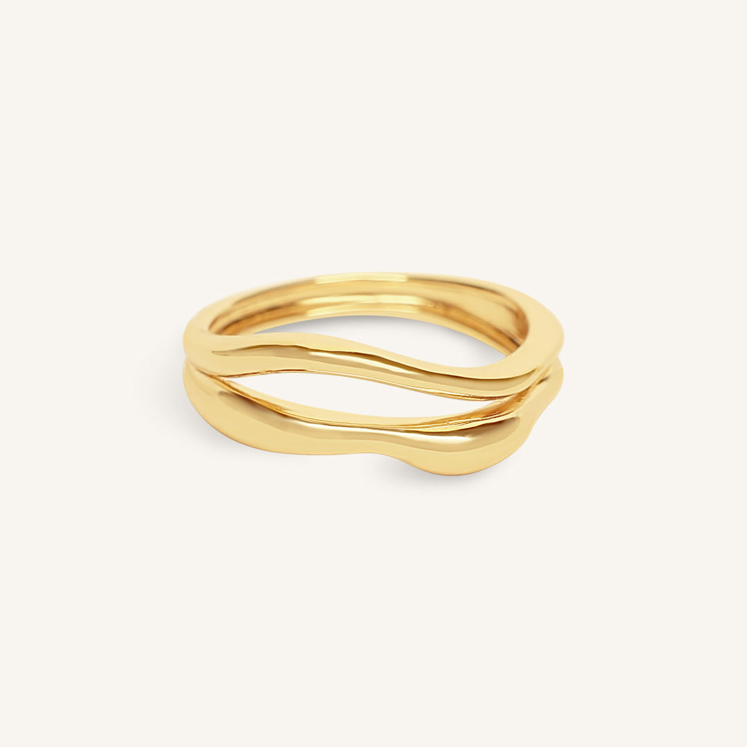 Gold ring with wavy design on a white background