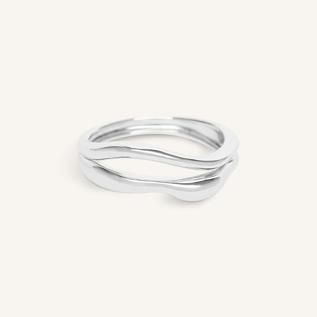Silver ring with wavy design on a white background