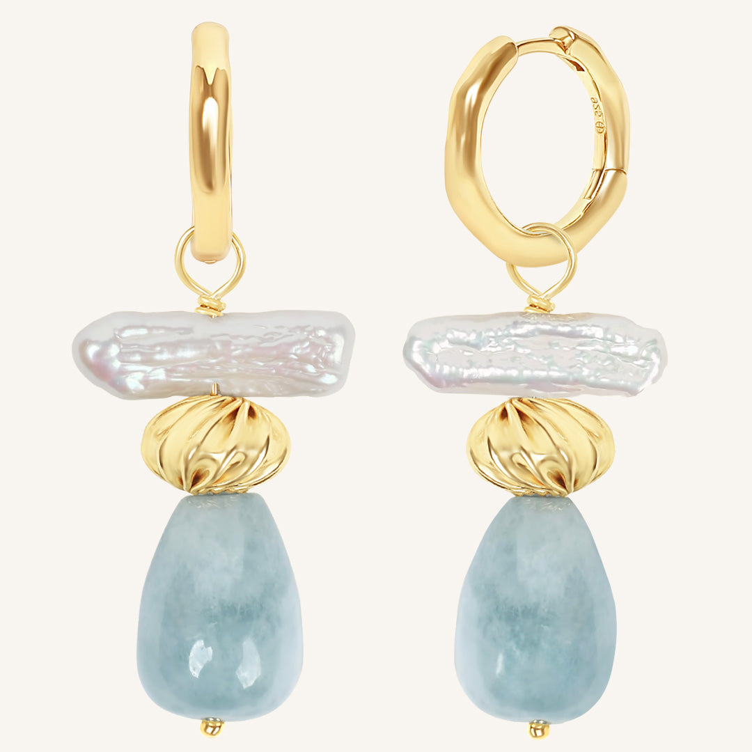 Gold and blue stone earrings on a white background