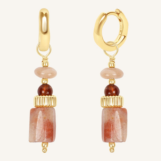 Gold hoop earrings with stone beads on a white background