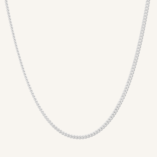 Silver chain necklace on a light gray background