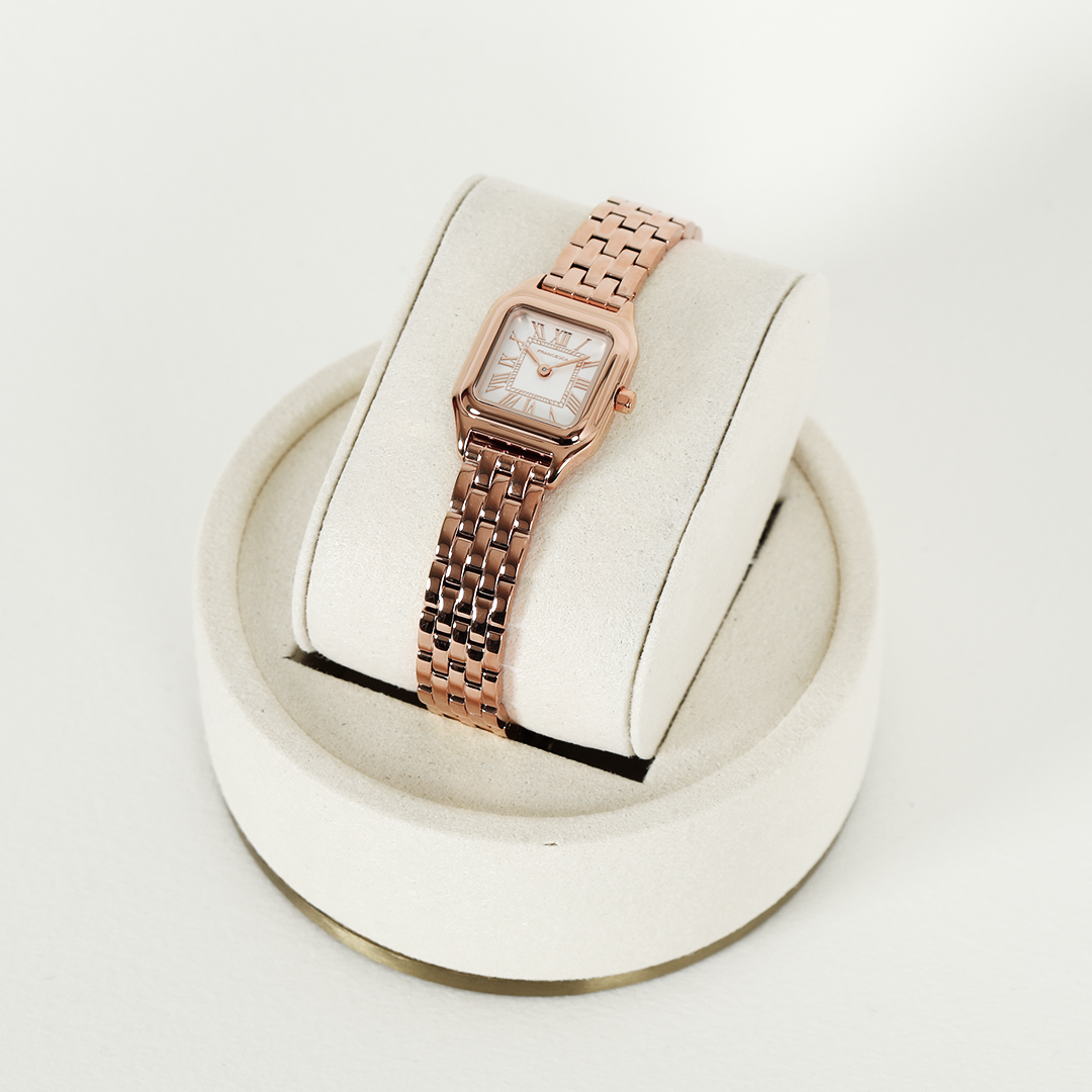 A rose gold-toned Louis Watch with a link bracelet and a square face featuring Roman numerals.